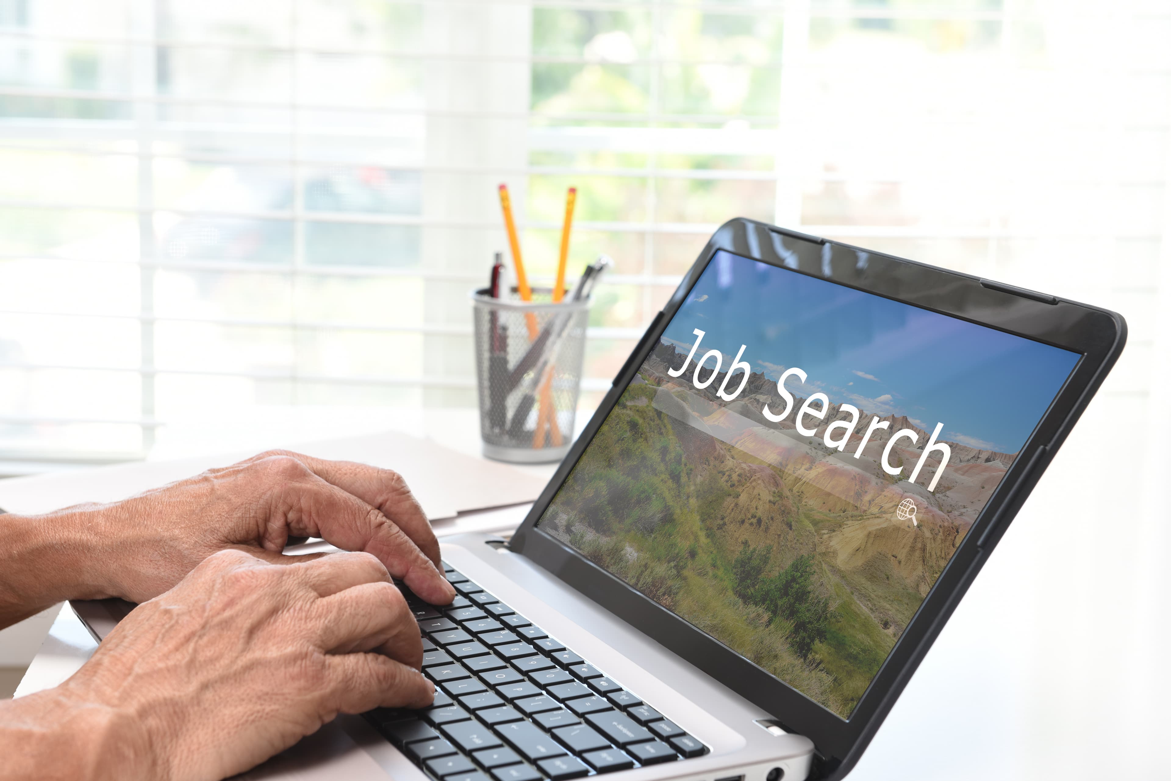 Persona buscando empleo en laptop en oficina en casa