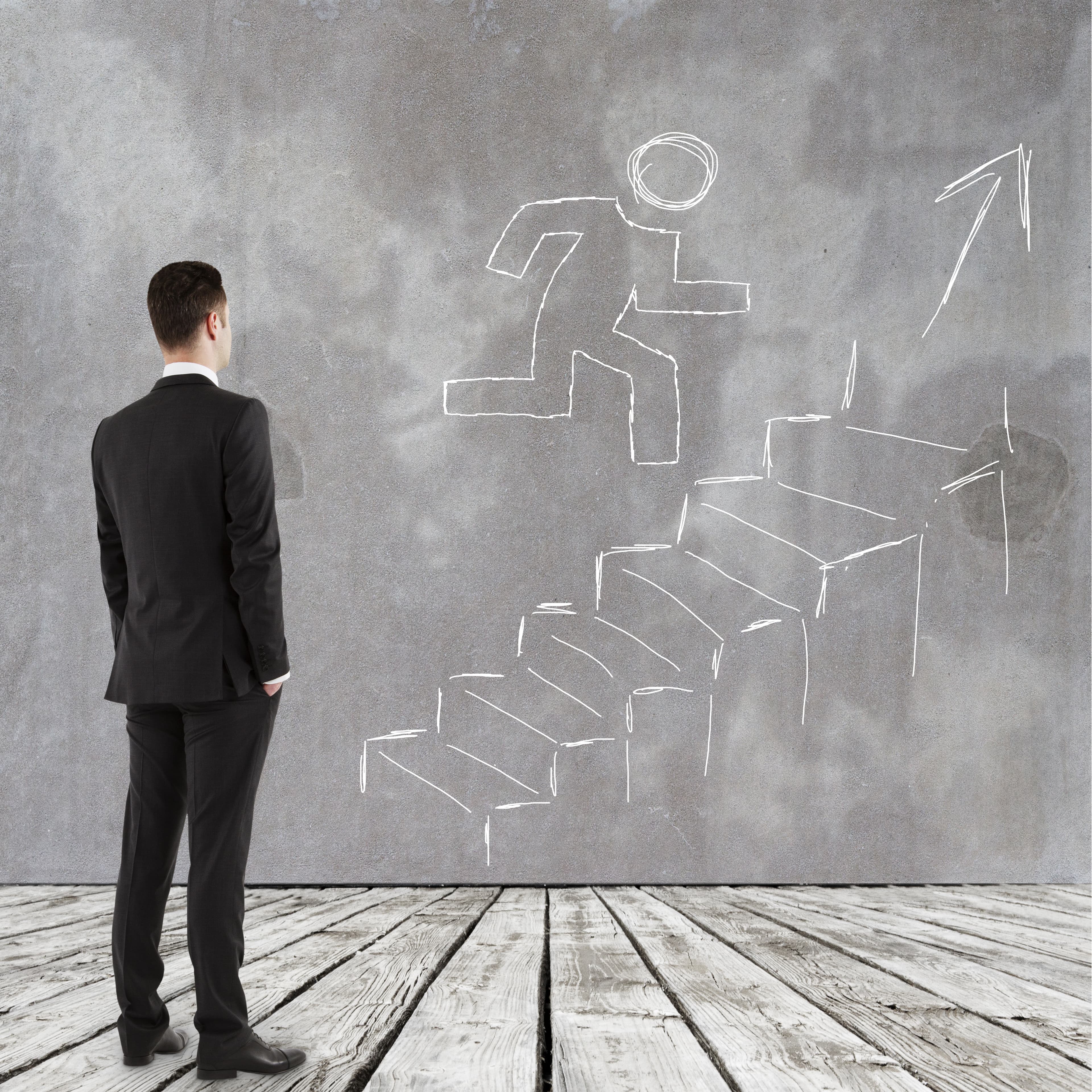 Hombre de traje contemplando escalera que representa siguiente paso profesional